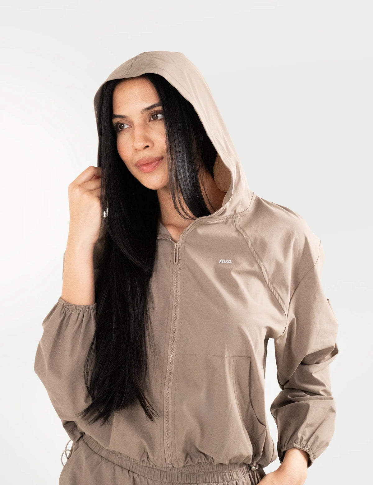 Chaqueta AVA Libre en color nude, vista frontal con la capucha puesta.